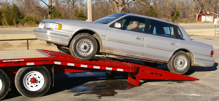 Twenty-six foot 7K trailer, equipped with six foot ramps being loaded with this low ground clearance vehicle