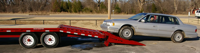 Twenty-six foot 7K trailer, equipped with six foot ramps being loaded with this low ground clearance vehicle.